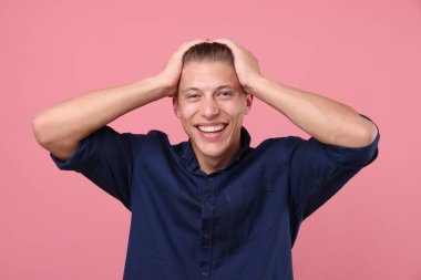 Pembe arka planda gülen yakışıklı bir adam. Pozitif duygu