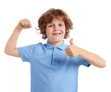 Kuvvet. Küçük mutlu çocuk beyaz arka planda bisepslerini ve başparmaklarını gösteriyor.