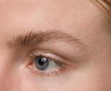 Kaş şekillendirme. Güzel kaşlı genç bir kadın, yakın plan.