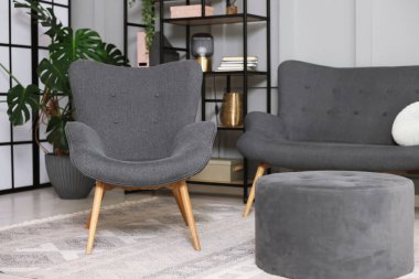 Şık gri koltuk, kanepe ve içeride puf. İç tasarım