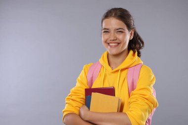 Not defterleri olan öğrenci gri arka plandaki iyi sınav sonucundan memnun.