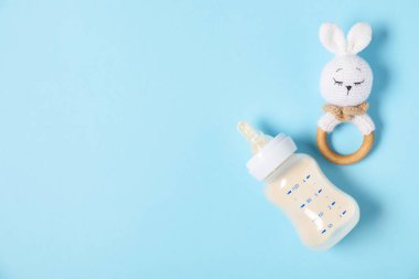 Besleme şişesi, formül ve açık mavi arka planda ip, düz bir zemin. Metin için boşluk