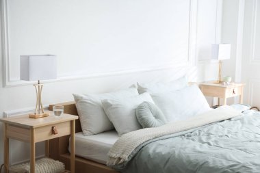 Yatağın yanında lambalar olan komodinlerin yanına.