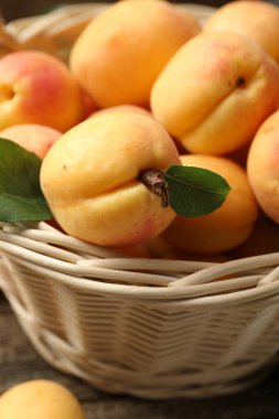 Hasır sepetteki taze kayısılar masada, yakın plan.