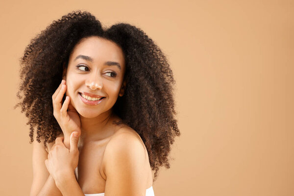 Portrait of beautiful Brazilian woman on beige background, space for text