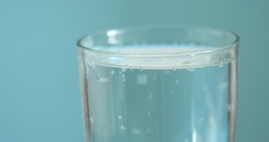 Soda bardakta tazeleniyor turkuaz arka plan, yakın plan