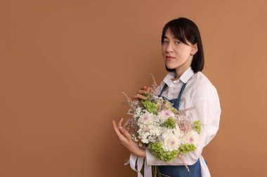 Koyu bej arka planda güzel çiçek buketi olan çiçekçi, metin için boşluk.