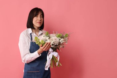 Pembe arka planda çiçek buketi olan bir çiçekçi, mesaj için yer.