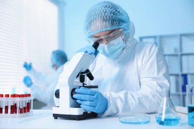 Tıbbi analiz. Laboratuvarda mikroskopla çalışan bilim adamı, seçici odaklanma