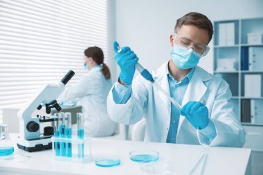 Tıbbi analiz. Laboratuvarda numuneyle çalışan bilim adamı, seçici odaklanma