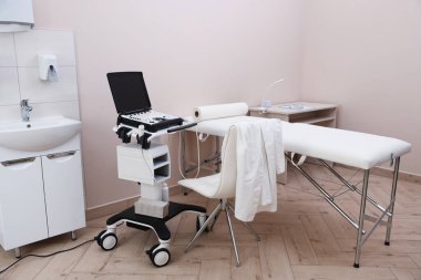 Modern ultrason makinesi ve klinikte muayene yatağı