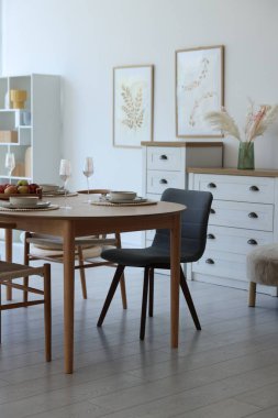 Yemek odasında güzel bir masa, sandalye ve dekor var. İç tasarım