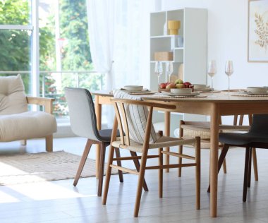 Yemek odasında güzel bir masa, sandalye ve dekor var. İç tasarım