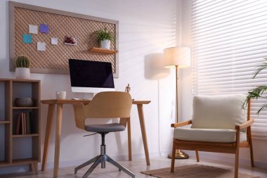 Ev ofisinde ahşap masası ve bilgisayarı olan şık bir iş yeri. İç tasarım