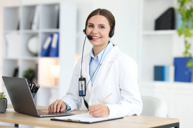 Teletıp. Doktor içeride bilgisayarla hastayla görüntülü konuşma yaparken not alıyor.