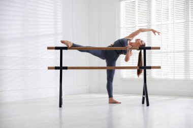 Stüdyoda barda esneme hareketleri yapan profesyonel dansçı.