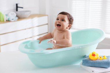 Evde küvette banyo yapan şirin bir bebek.