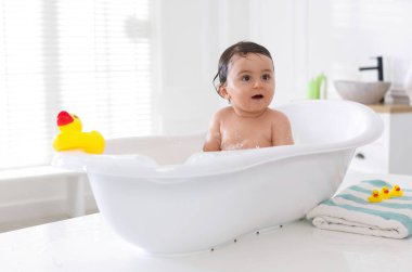 Evde küvette banyo yapan şirin bir bebek.