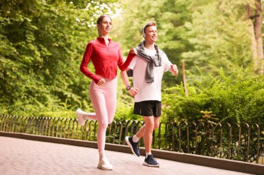 Parkta koşan mutlu çift, düşük açı. Sabah egzersizi