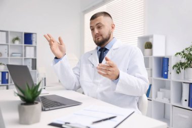 Klinikte bilgisayarla online danışmanlık yapan bir doktor