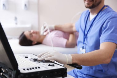 Sonograf klinikte kadının tiroid bezini ultrason taraması yapıyor.