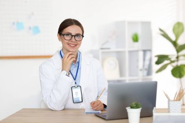 Teletıp. Doktor içeride bilgisayarla hastayla görüntülü konuşma yaparken not alıyor.