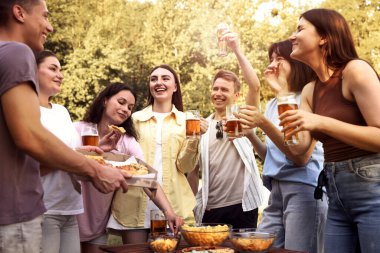 Bir grup mutlu arkadaş dışarıda bira içip eğleniyorlar.