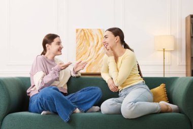 Arkadaşlar kanepede gülüyor. Pozitif duygu