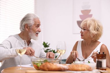 Evde yemek yiyen yaşlı bir çift.