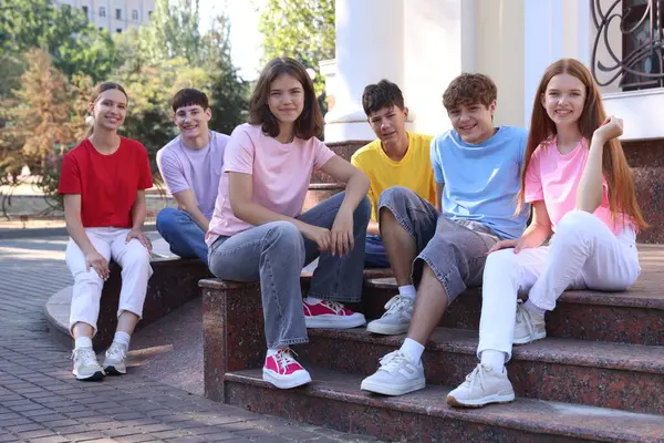 Bir grup mutlu genç arkadaş dışarıda vakit geçiriyorlar.