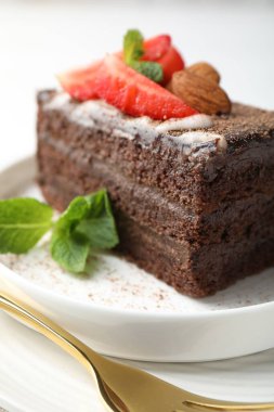 Çilekli, bademli ve naneli bir dilim lezzetli çikolatalı pasta.