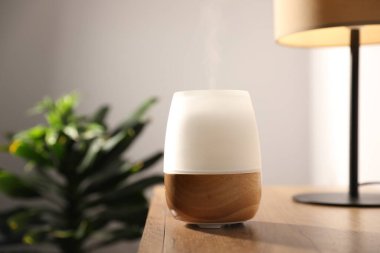 Ahşap masa üzerinde modern aroma lambası.