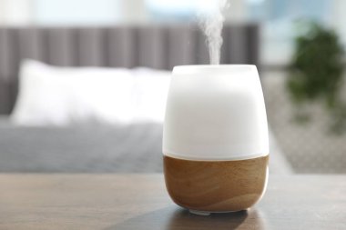 Ahşap masa üzerinde modern aroma lambası. Metin için boşluk