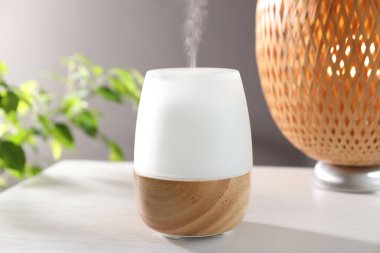 Beyaz ahşap masa üzerinde modern aroma lambası.