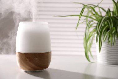 Beyaz masa üzerinde şık bir aroma lambası, yakın plan. Metin için boşluk