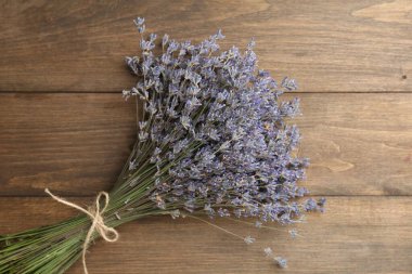 Ahşap masanın üstünde bir demet aromatik lavanta çiçeği.
