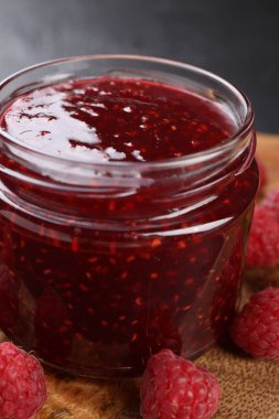 Cam kavanozda tatlı ahududu reçeli ve masada böğürtlen, yakın plan.
