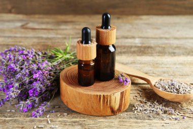 Ahşap masada taze ve kuru çiçekli lavanta yağı, yakın plan.