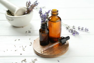 Lavanta yağı, çiçekler, harç ve tokmak beyaz ahşap masa, yakın çekim