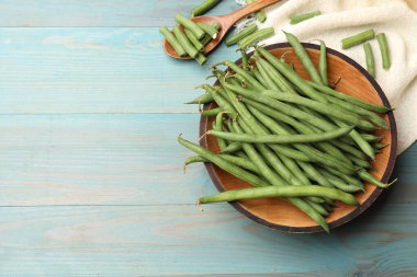 Mavi ahşap masada bir sürü çiğ yeşil fasulye vardı. Metin için boşluk