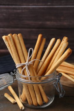 Lezzetli Grissini, açık cam kavanozda, ahşap masada, yakın plan.