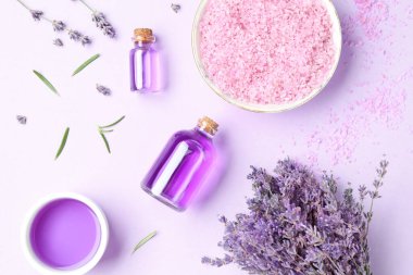 Aromatik gerekli yağ, deniz tuzu ve mor arka planda lavanta çiçekleri, düz yatıyordu.