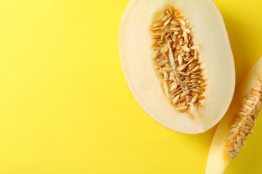 Sarı arka planda taze olgun kavun kes, düz yat. Metin için boşluk