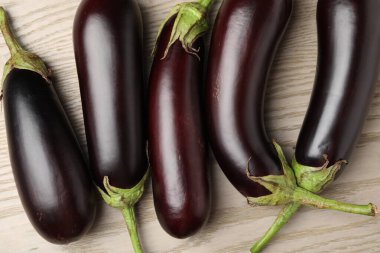 Pek çok olgun patlıcan açık ahşap masada, düz yatıyordu.