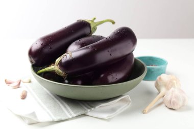 Beyaz masada bir sürü ıslak patlıcan ve sarımsak