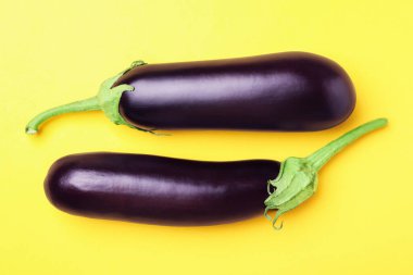 Sarı arka planda olgun patlıcanlar.