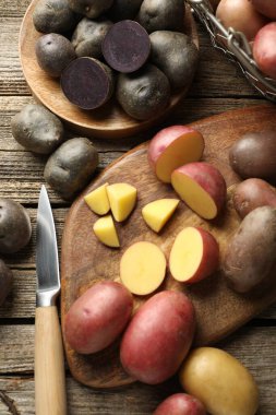 Farklı tipte patates ve bıçak tahta masada, düz yerde.