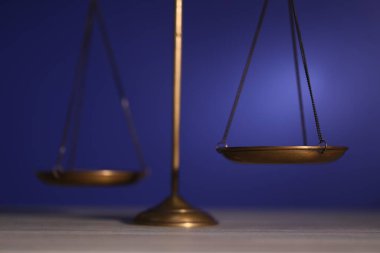 Adaletin terazisi ahşap masada, karanlık arka planda, yakın planda