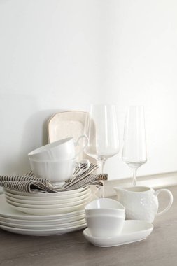 Mutfakta farklı beyaz bulaşık takımları ve bardaklar var.