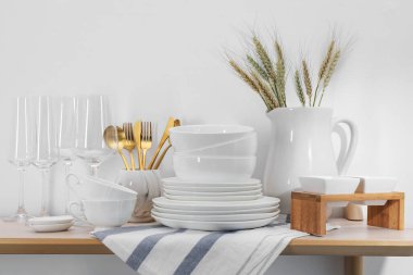 Temiz beyaz bulaşık takımı, bardaklar, çatal bıçak takımı ve çiviler.